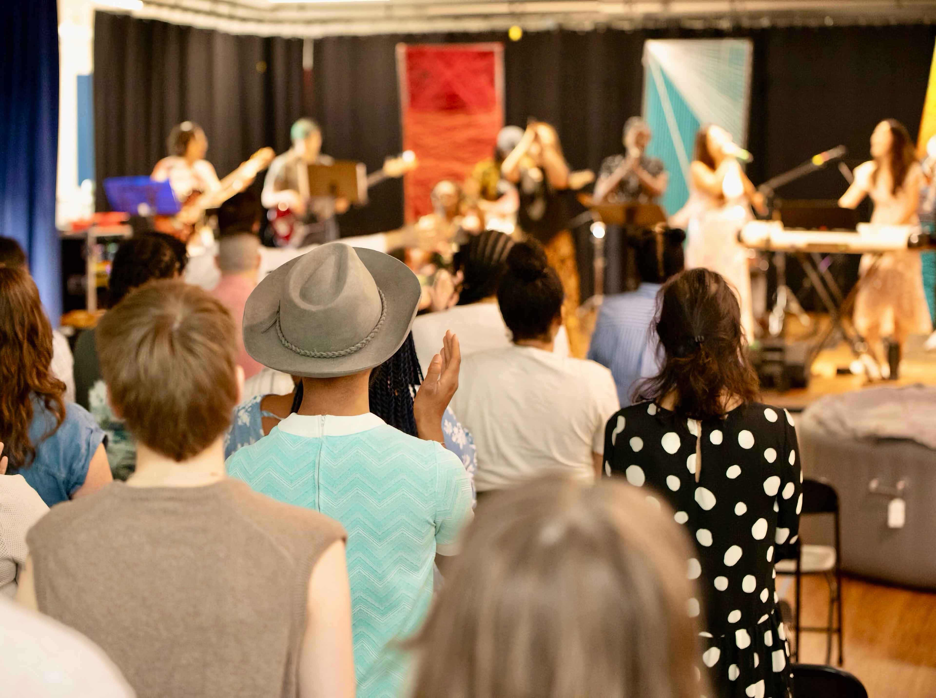 The congregation stands facing the band on a Sunday at DC Bilingual.
