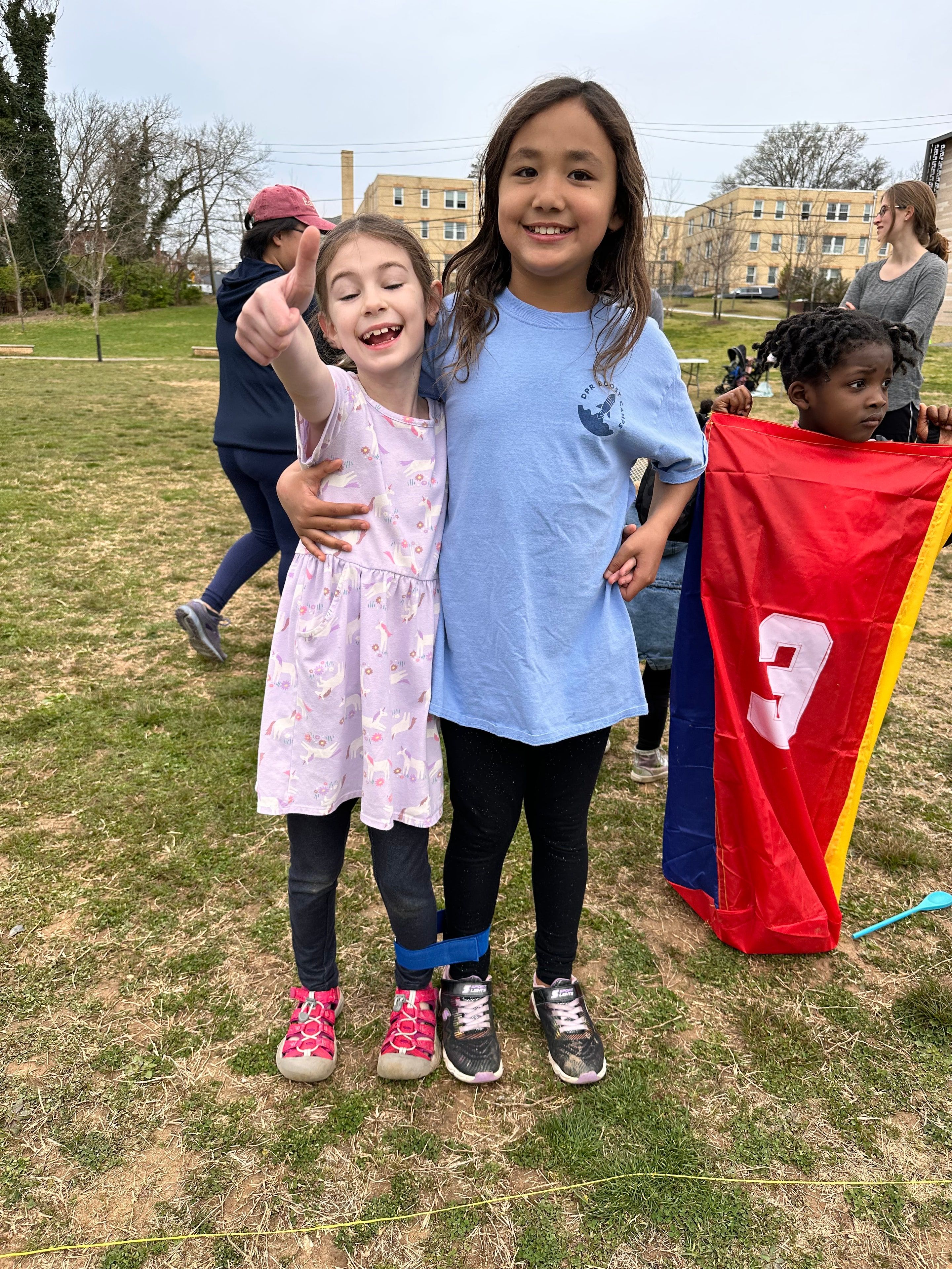 Two girls smile together at a church picnic.